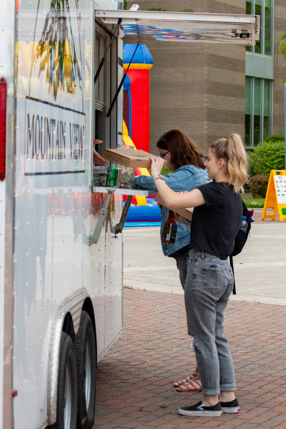 A student grabs her fresh pizza at the Mountain View food truck that was present during the Centralia College SpringFest Tuesday afternoon.